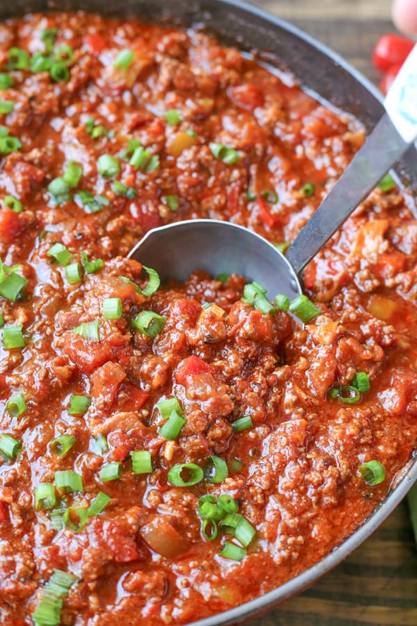 A ladle scooping up some hearty chili. 