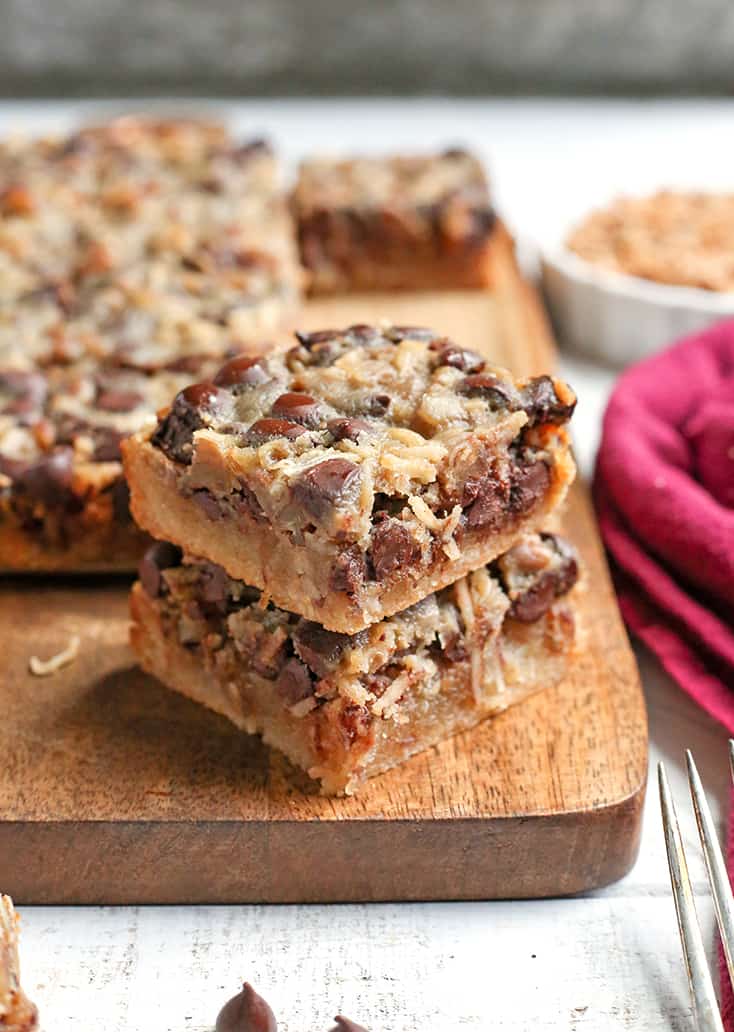 These Paleo Magic Cookie Bars are a healthier version of the classic dessert. A shortbread crust topped with shredded coconut, chopped pecans, chocolate chips and a homemade sweetened condensed milk poured on top. They are gluten free, dairy free, naturally sweetened with a vegan option.