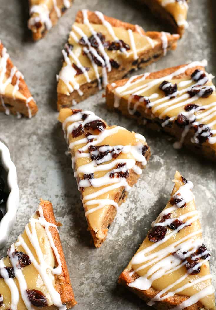 These Paleo Cranberry Bliss Bars have a thick cookie layer studded with chewy cranberries, topped with creamy dairy free cheesecake and a white drizzle. They are gluten free, dairy free, and naturally sweetened. 